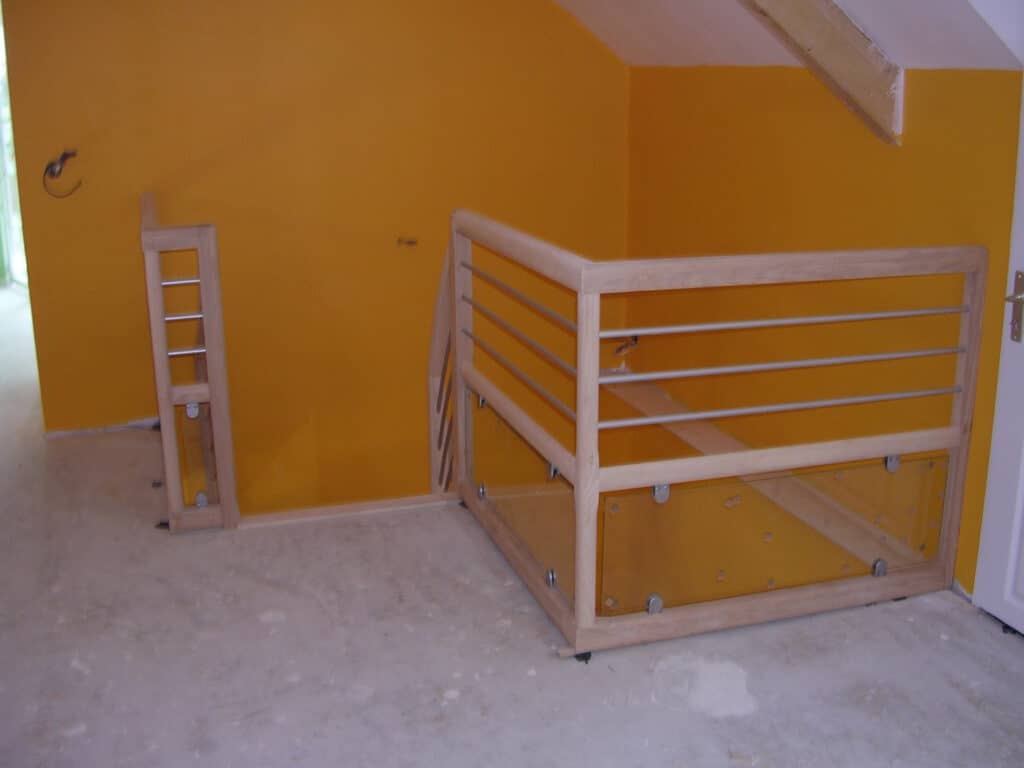 Garde-corps d'escalier moderne en bois clair avec traverses métalliques horizontales et panneaux de verre teinté jaune.